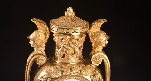 Antiquités - Vase pendule en plaqué or "Aux têtes de guerriers", circa 1810
