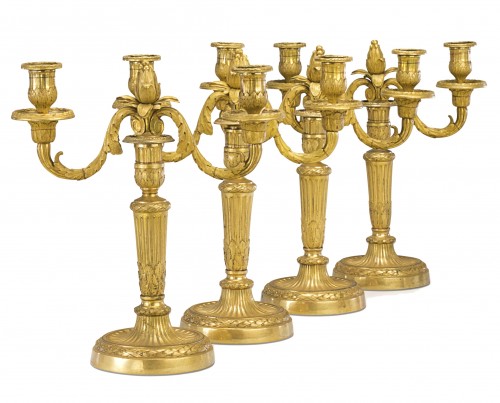 A set of four Louis XVI gilt bronze two-light candelabra after Delafosse