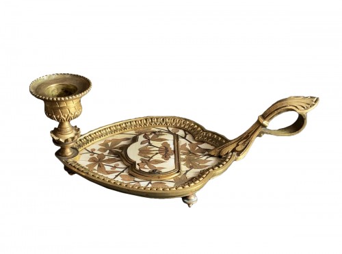 An ormolu mounted candlestick with match striker