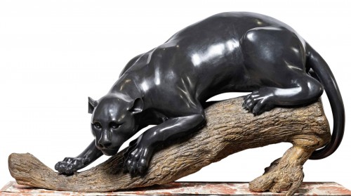 A bronze group of a panther on a branch
